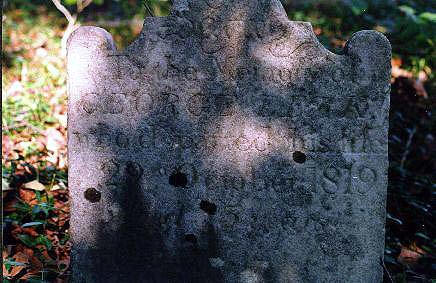 Worn headstone with a broken top in the Holland–Leak–Adair burying ground