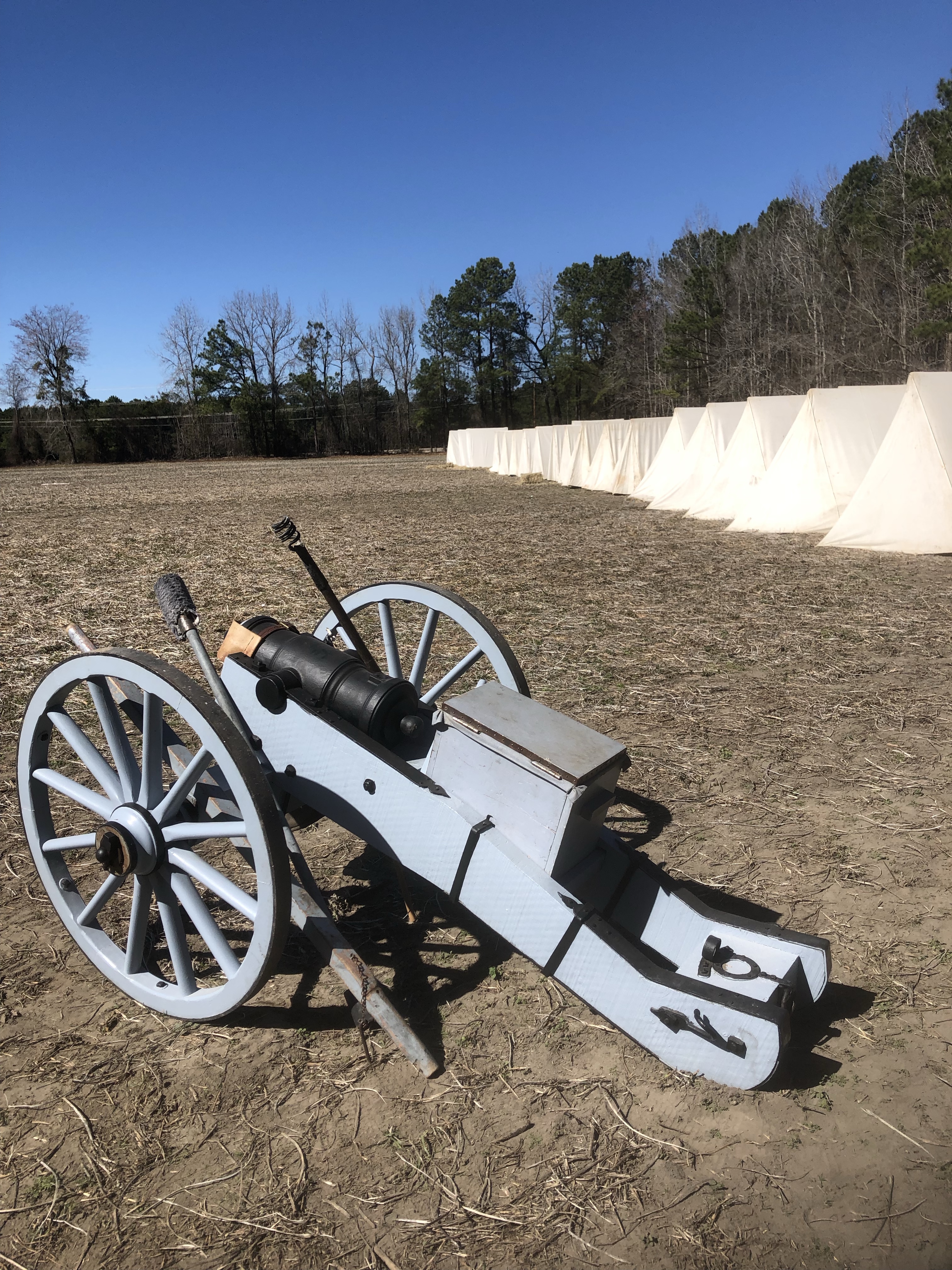 Field cannon on its carriage beside the camp tents