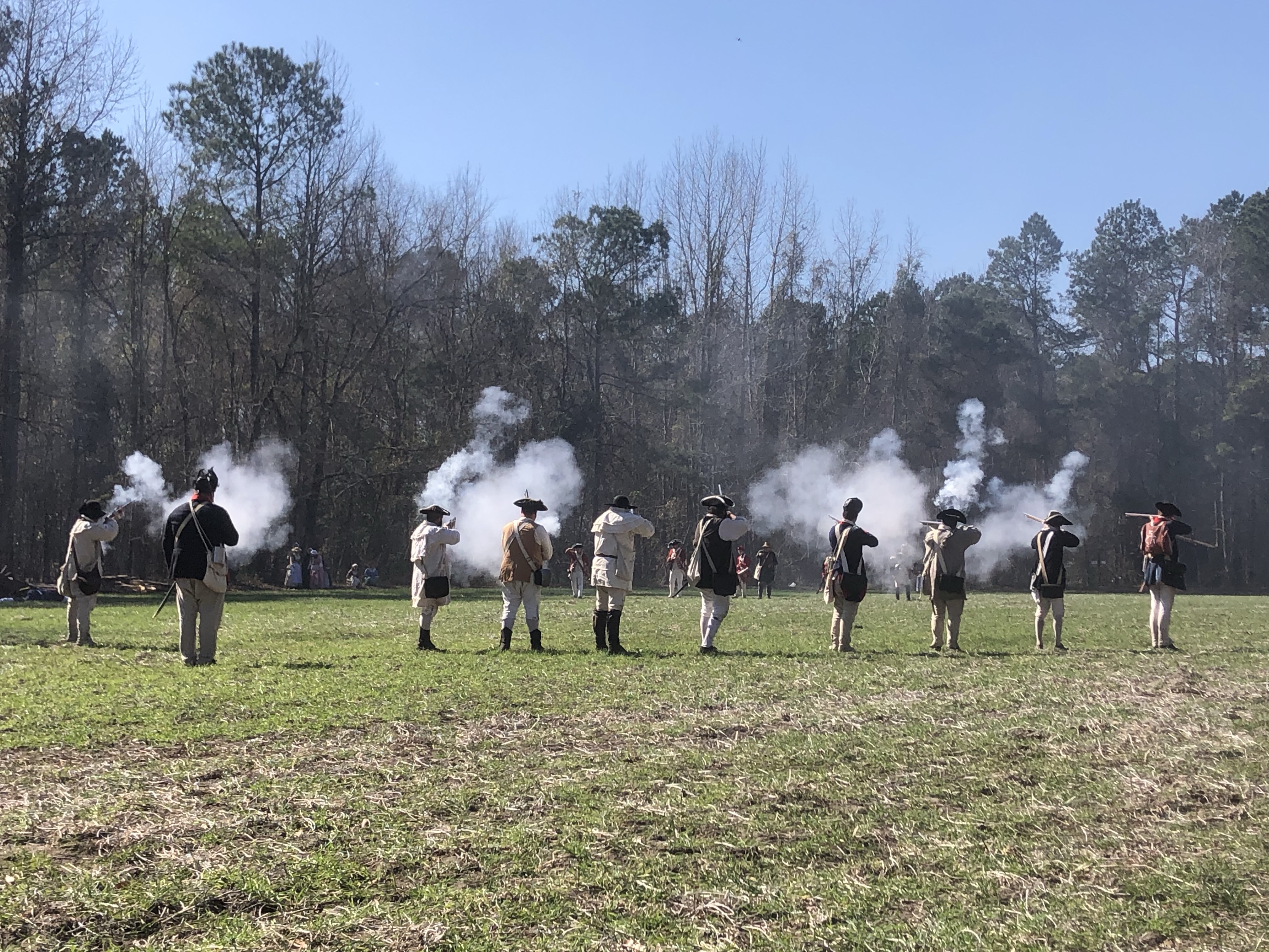 Two lines of reenactors firing at each other across the field