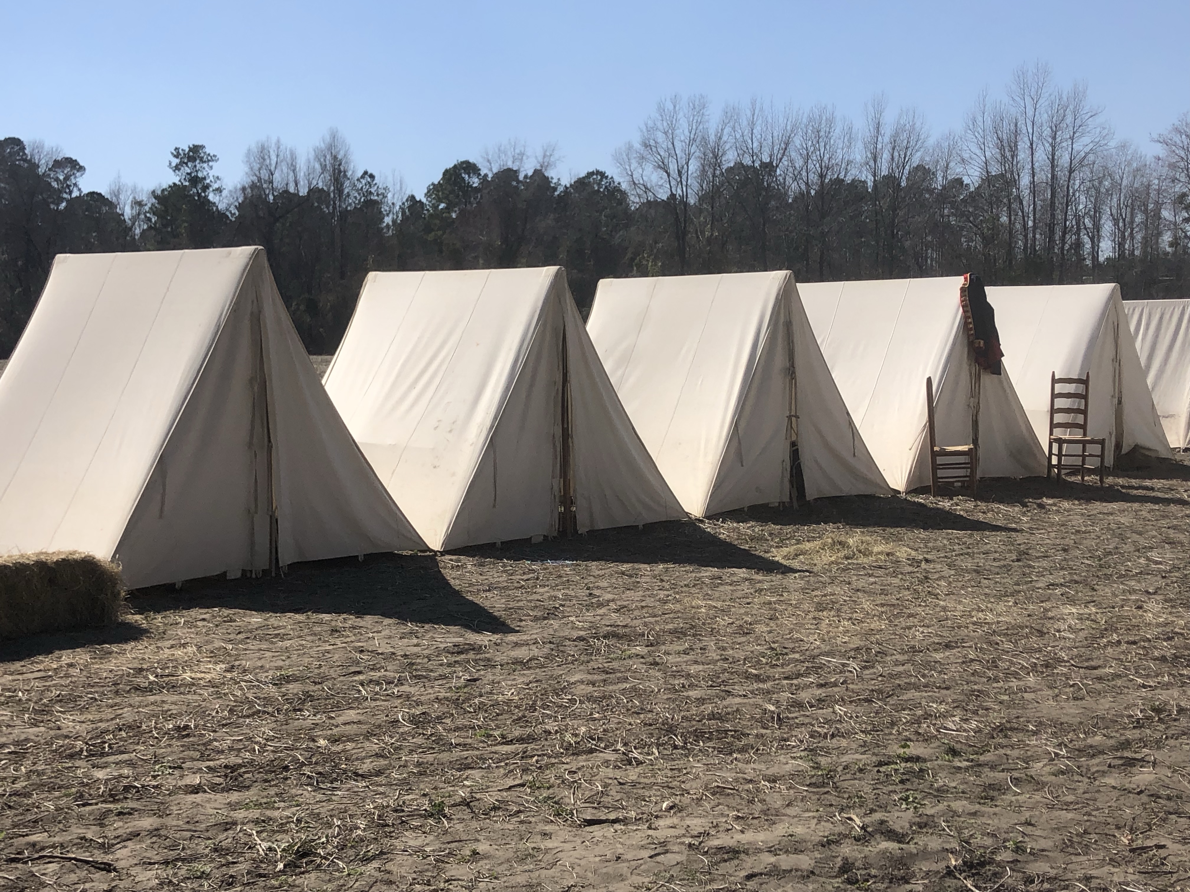 Row of white wedge tents under a blue sky