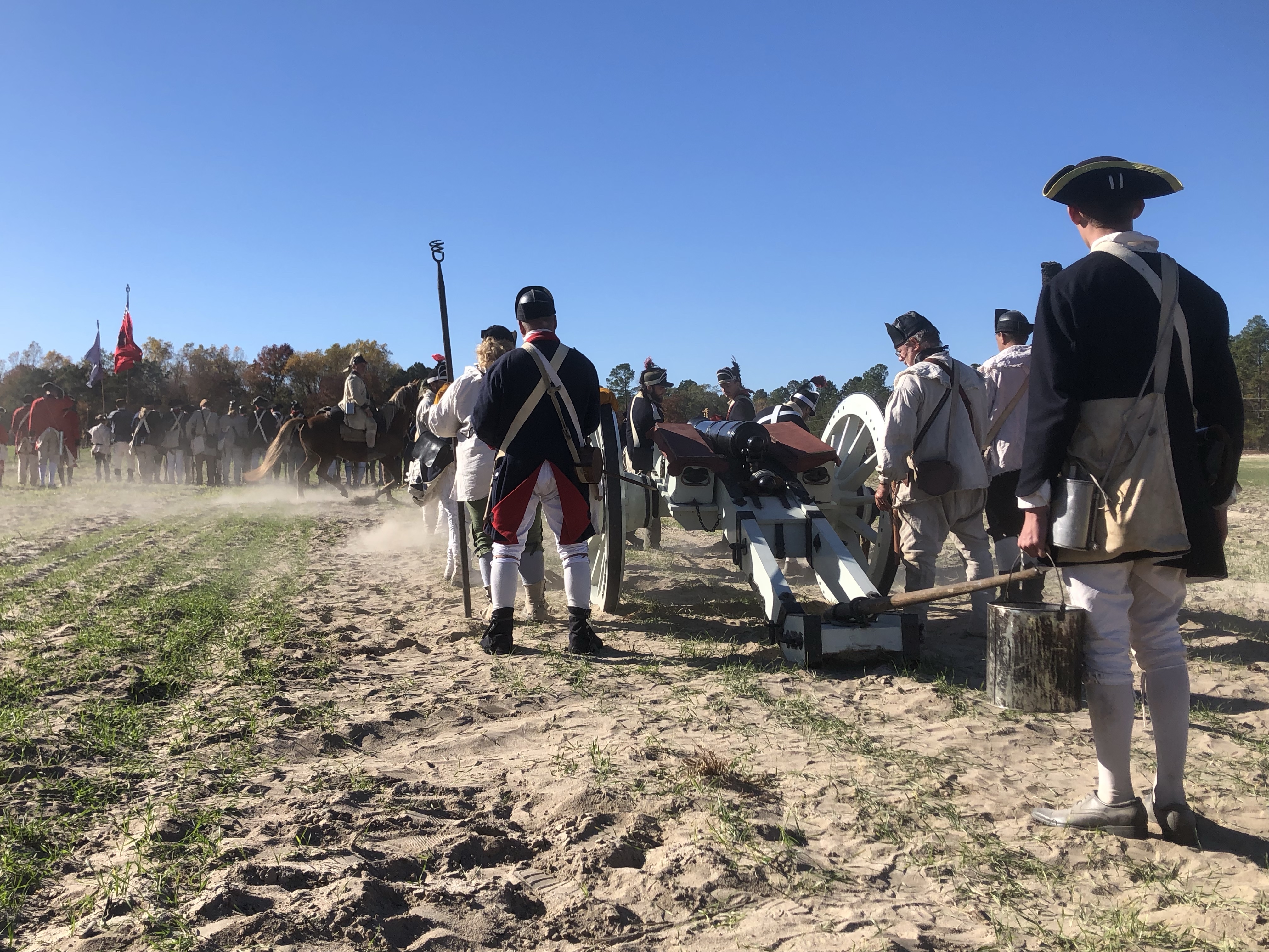 Artillery crew in blue coats and tricorn hats working a cannon