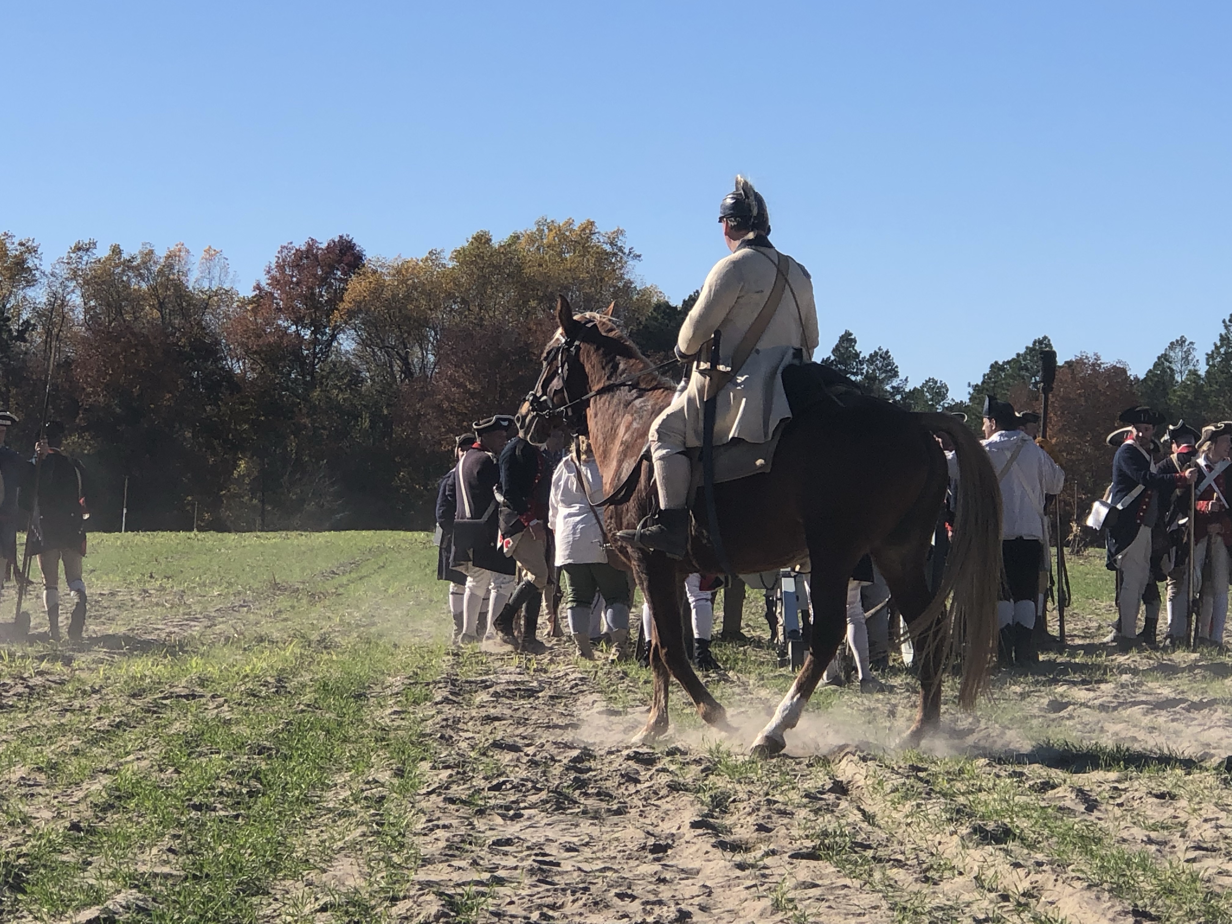 Reenactor on horseback riding across the battlefield