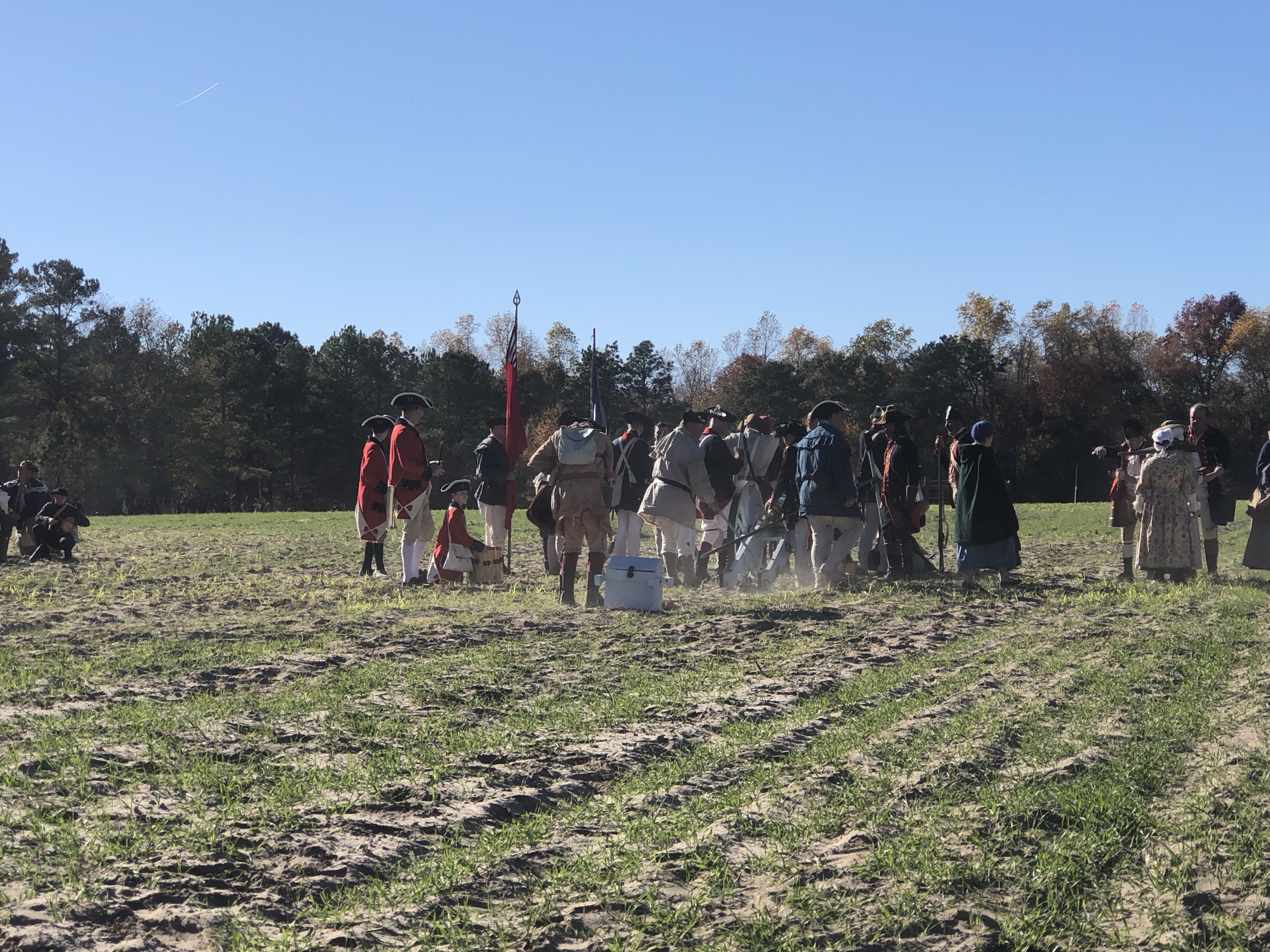 Lines of reenactors in Continental and British uniforms on the field