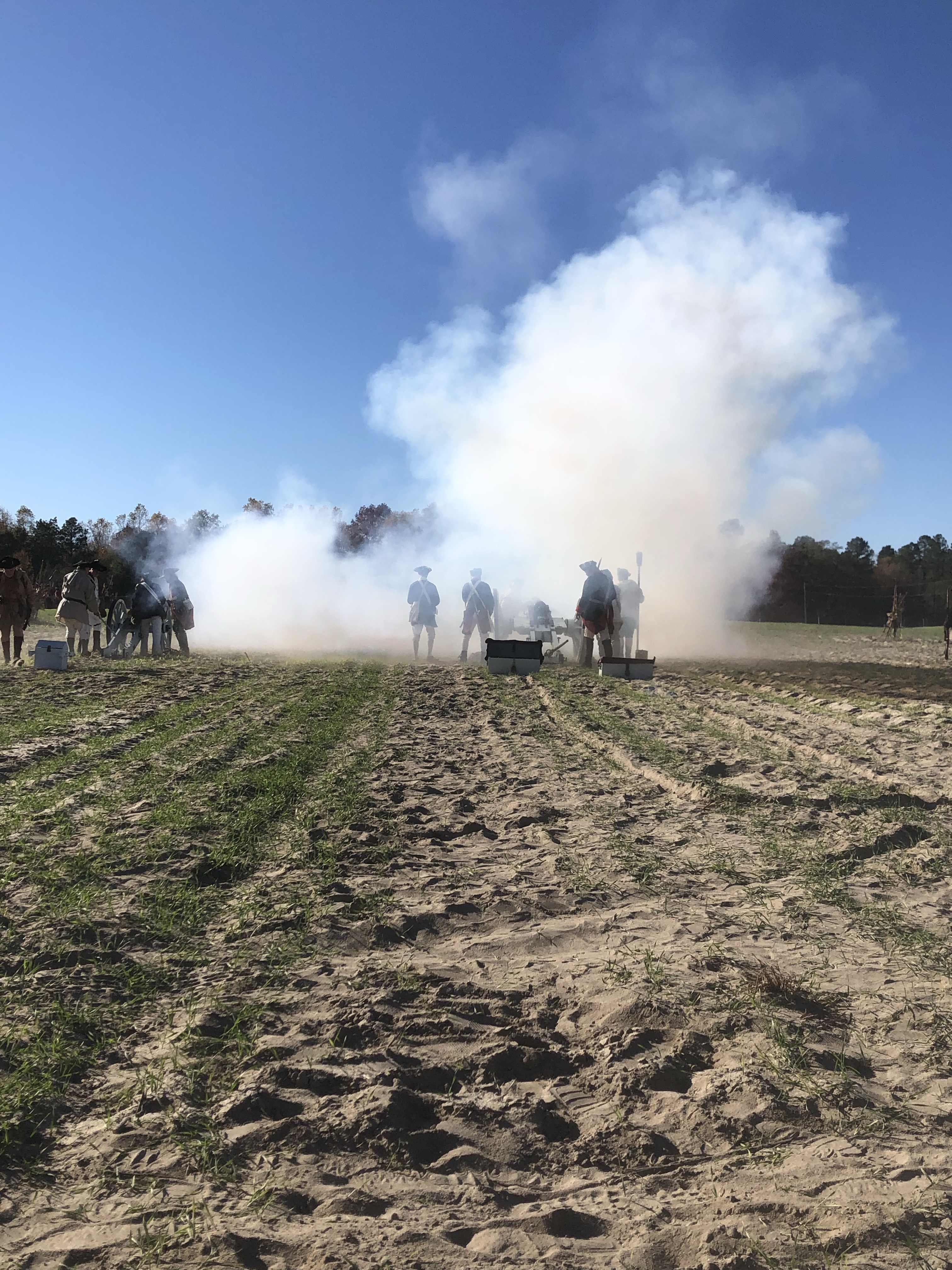 Large cloud of white smoke from cannon fire across the reenactment field