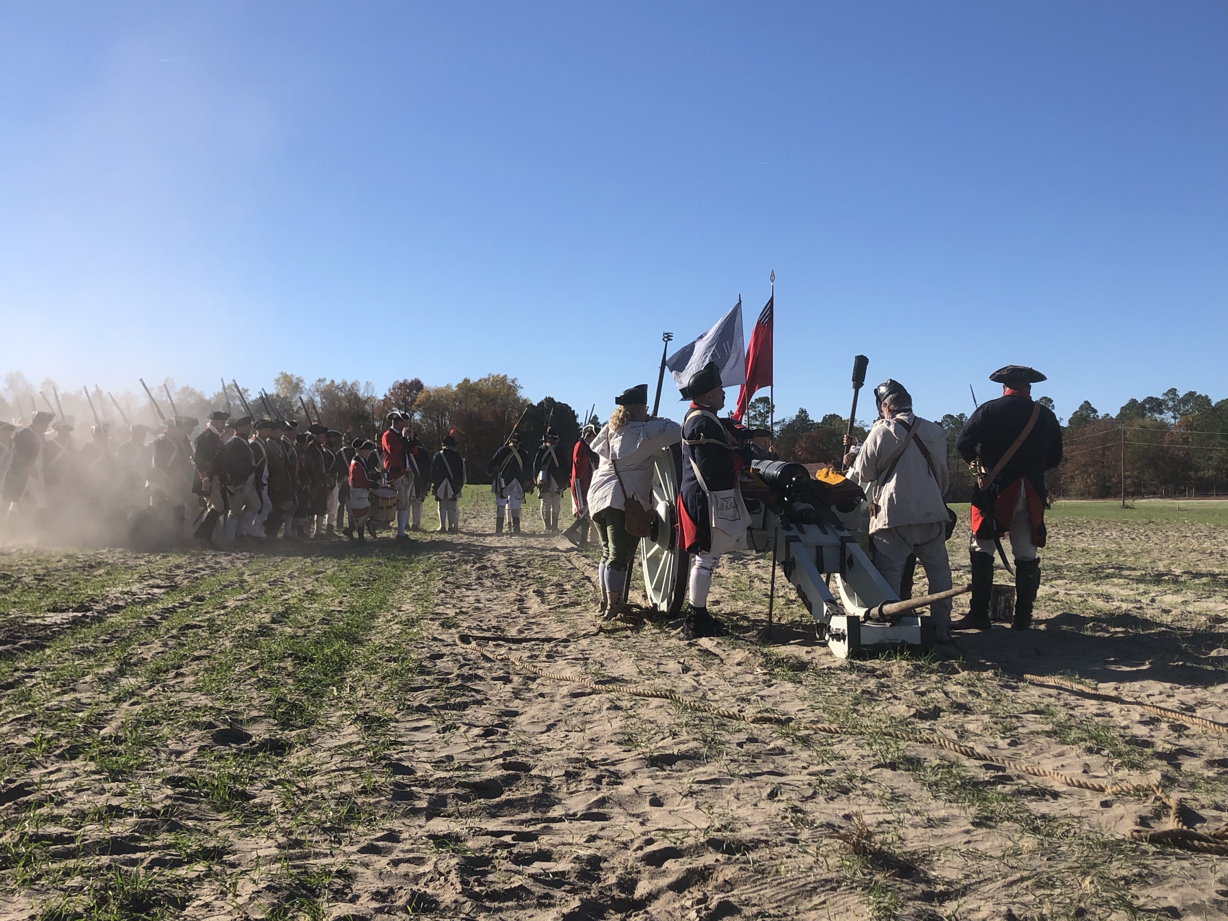 Artillery crew and flag bearers on the reenactment field at Camden
