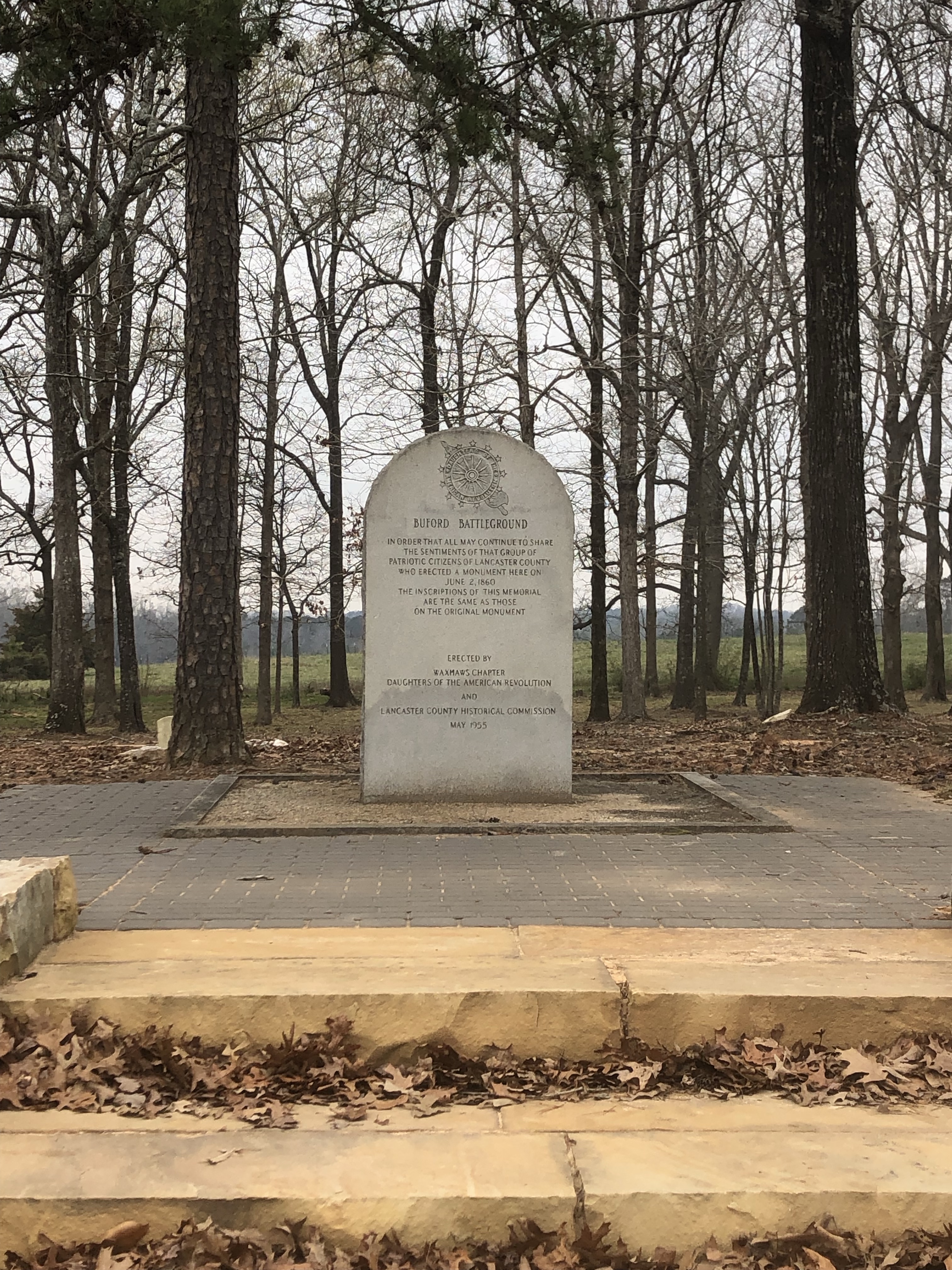 Granite monument at the top of stone steps among trees at the Waxhaws battlefield
