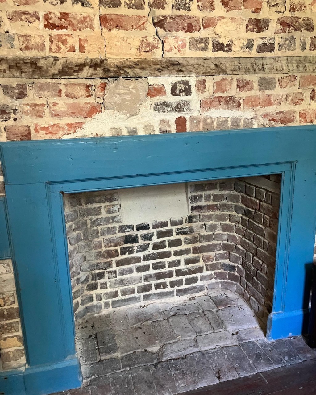 Brick fireplace with a blue wooden surround