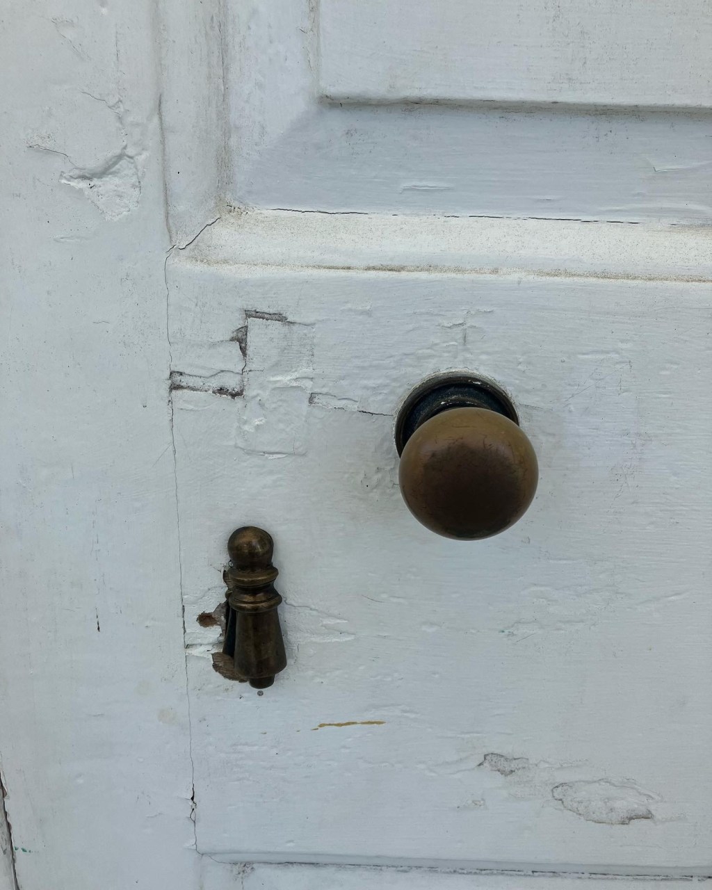 Brass door knob and iron latch on a painted door at Hampton