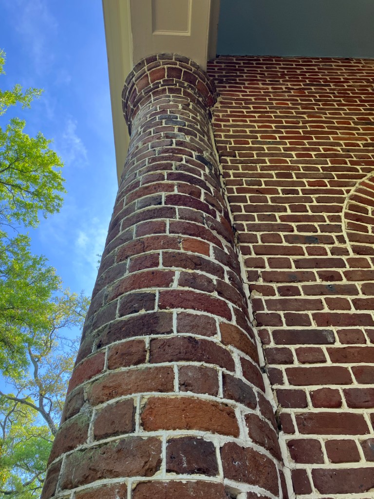 Looking up a curved brick column on the porch of St. James Santee Church