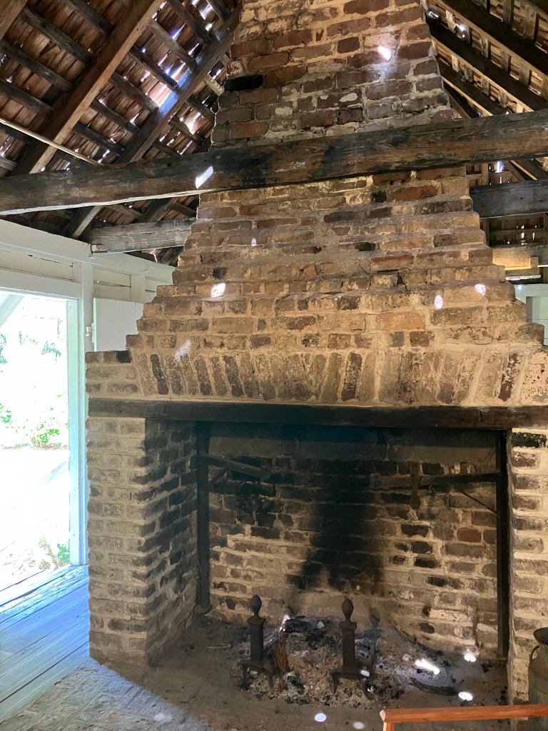 Old brick fireplace with iron andirons