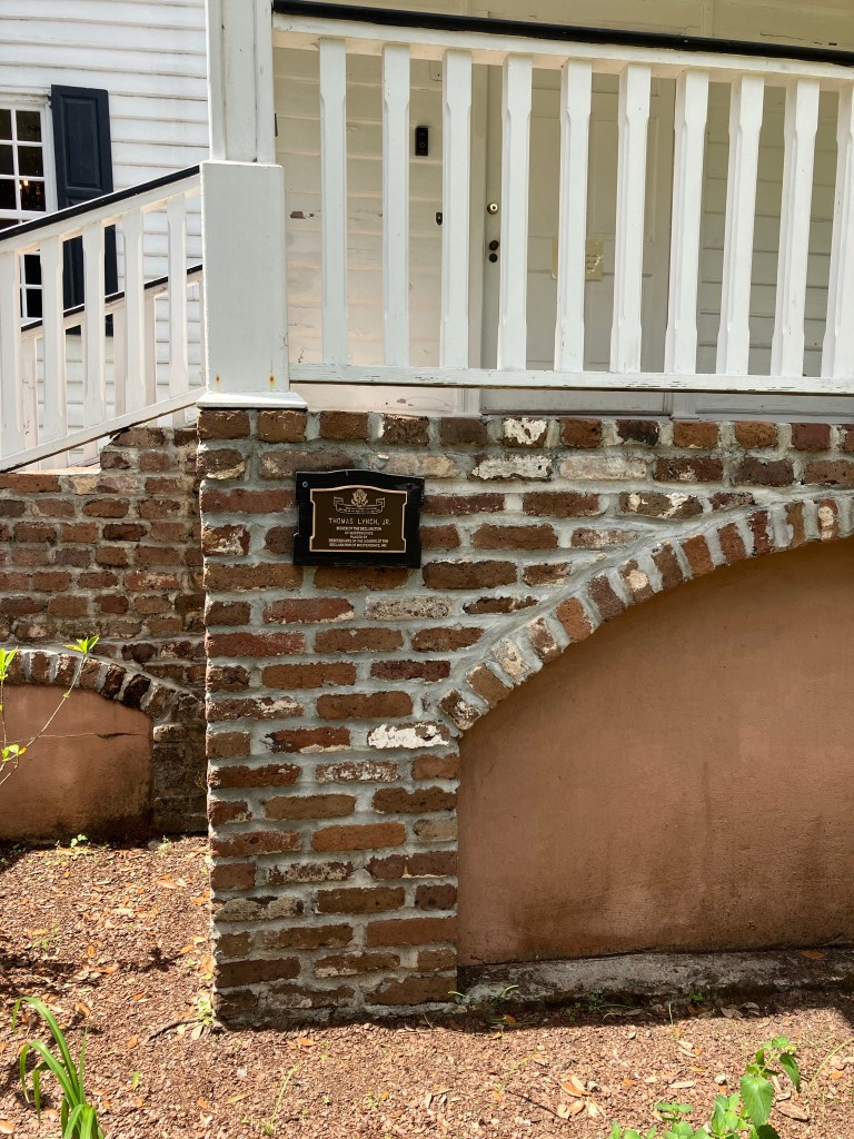 Brick foundation arches and white porch railings of the house