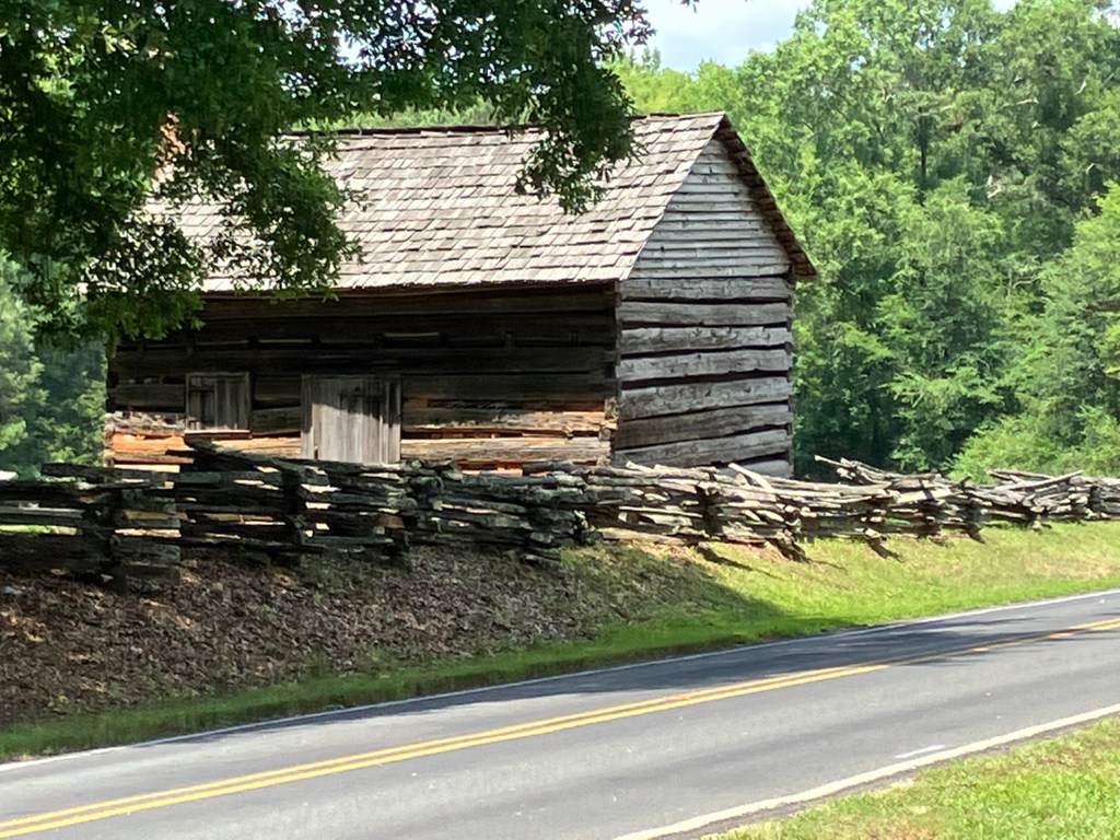 Log building and rail fence beside the road at Historic Brattonsville