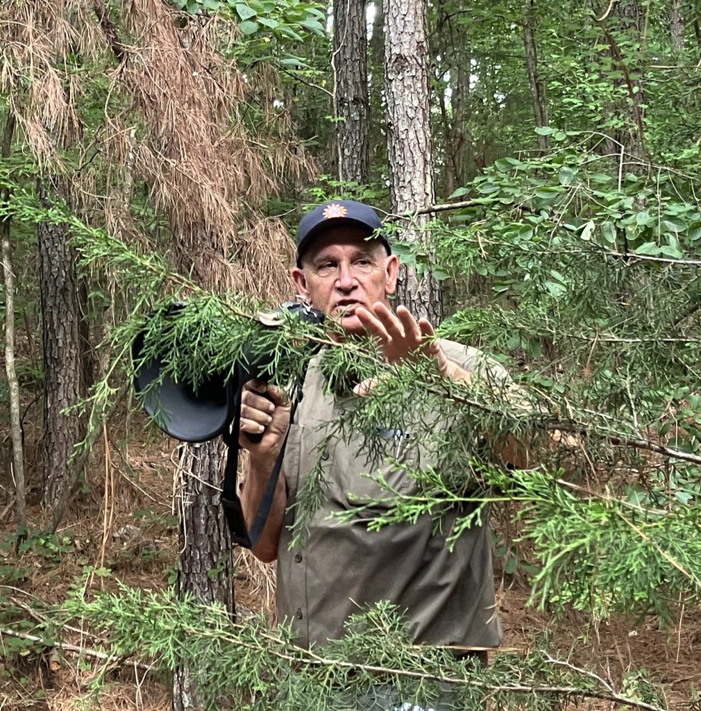 Durant Ashmore speaking with a megaphone among the pines at Hammond's Old Store