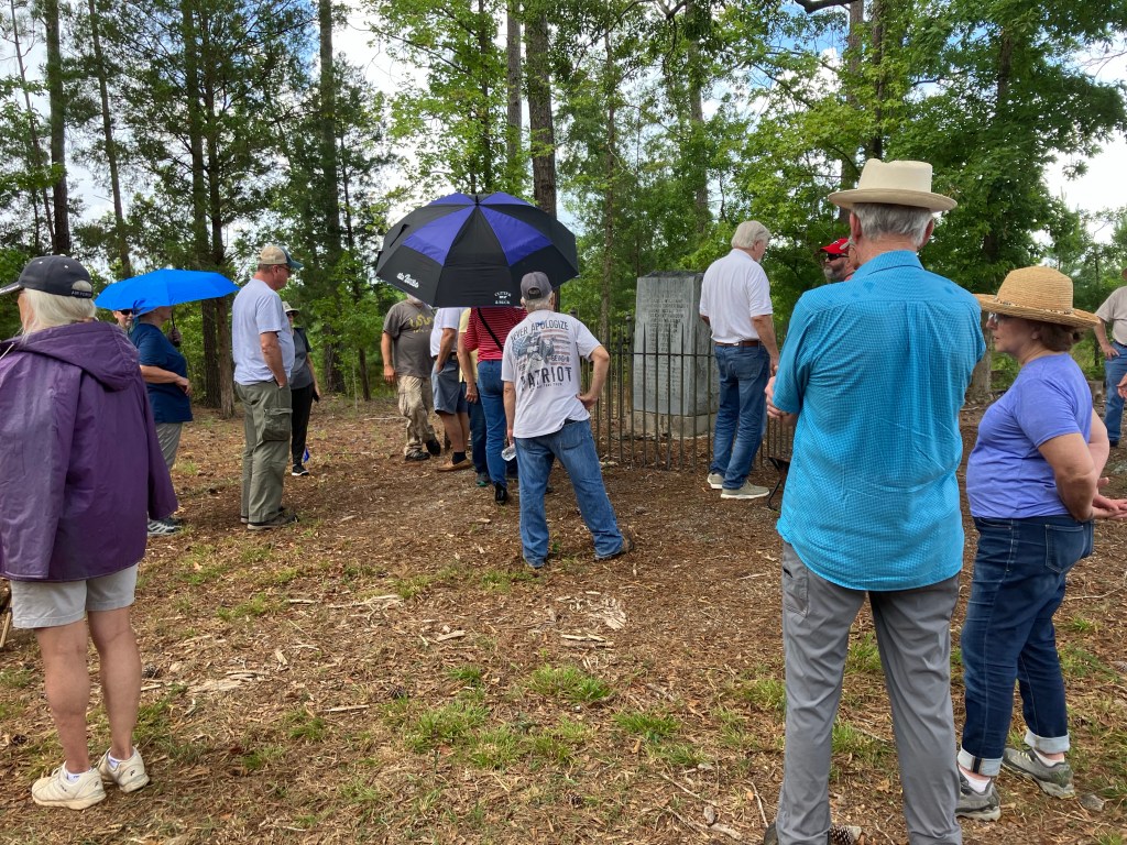 Visitors with umbrellas gathered around the Hayes Station monument