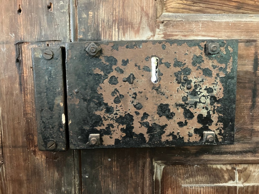 Rusted iron box lock on a wooden door
