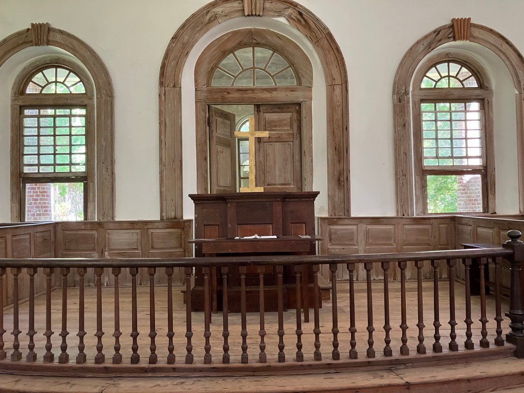 The pulpit framed by arched windows behind the rail
