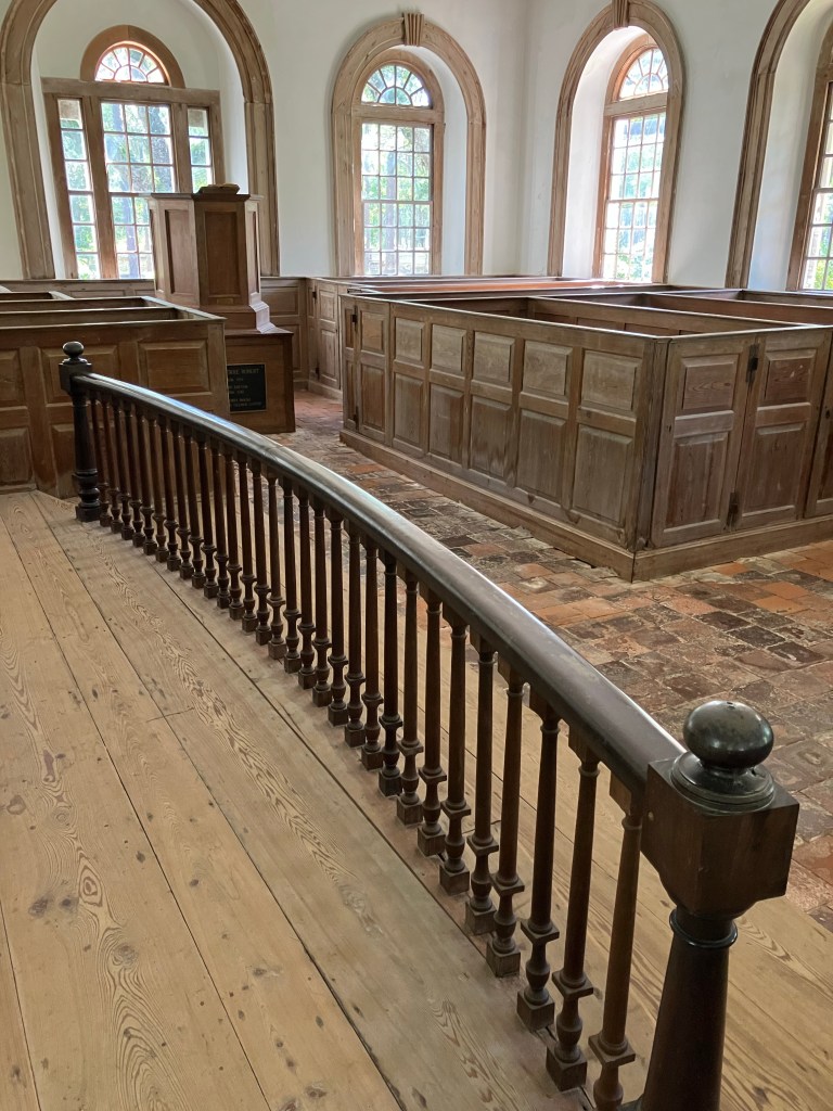 Turned wooden chancel rail curving around the altar area