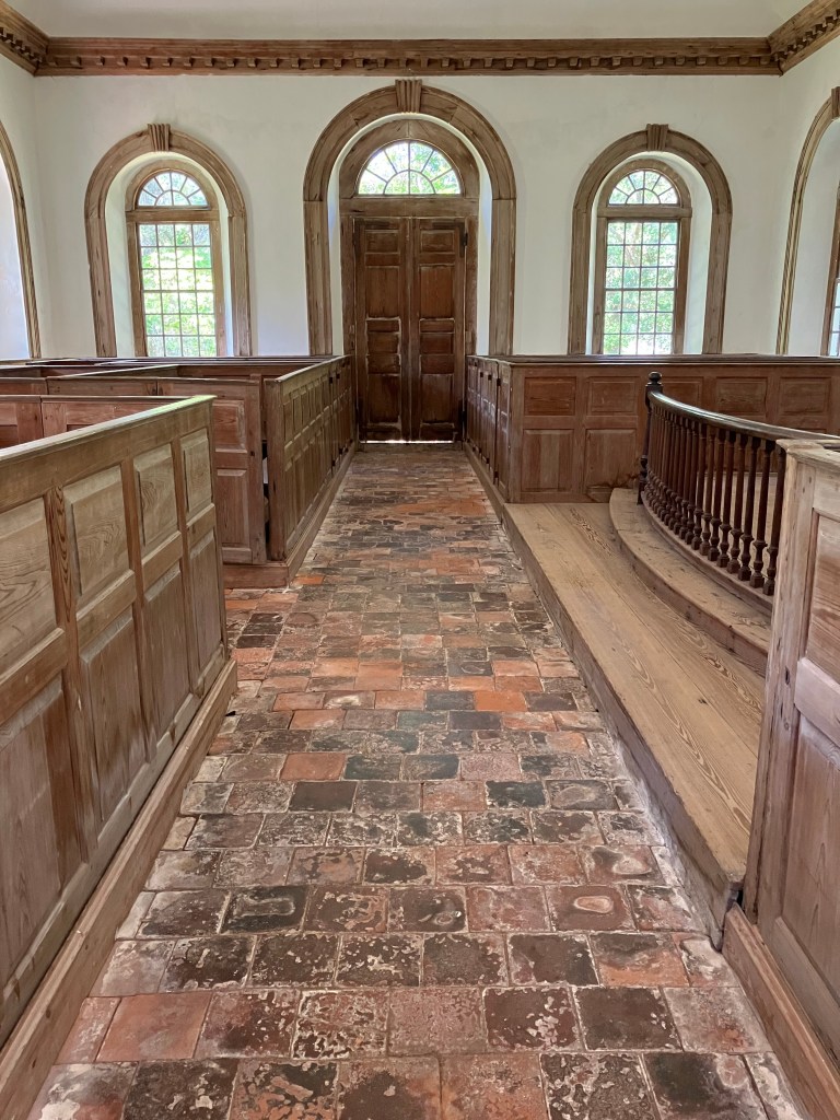 Tiled aisle leading to the paneled doors