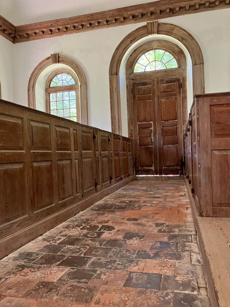 Tiled aisle between paneled pews