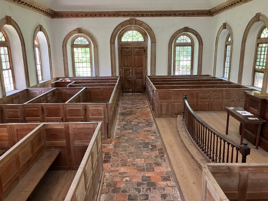 Long view of the nave with box pews and brick aisle