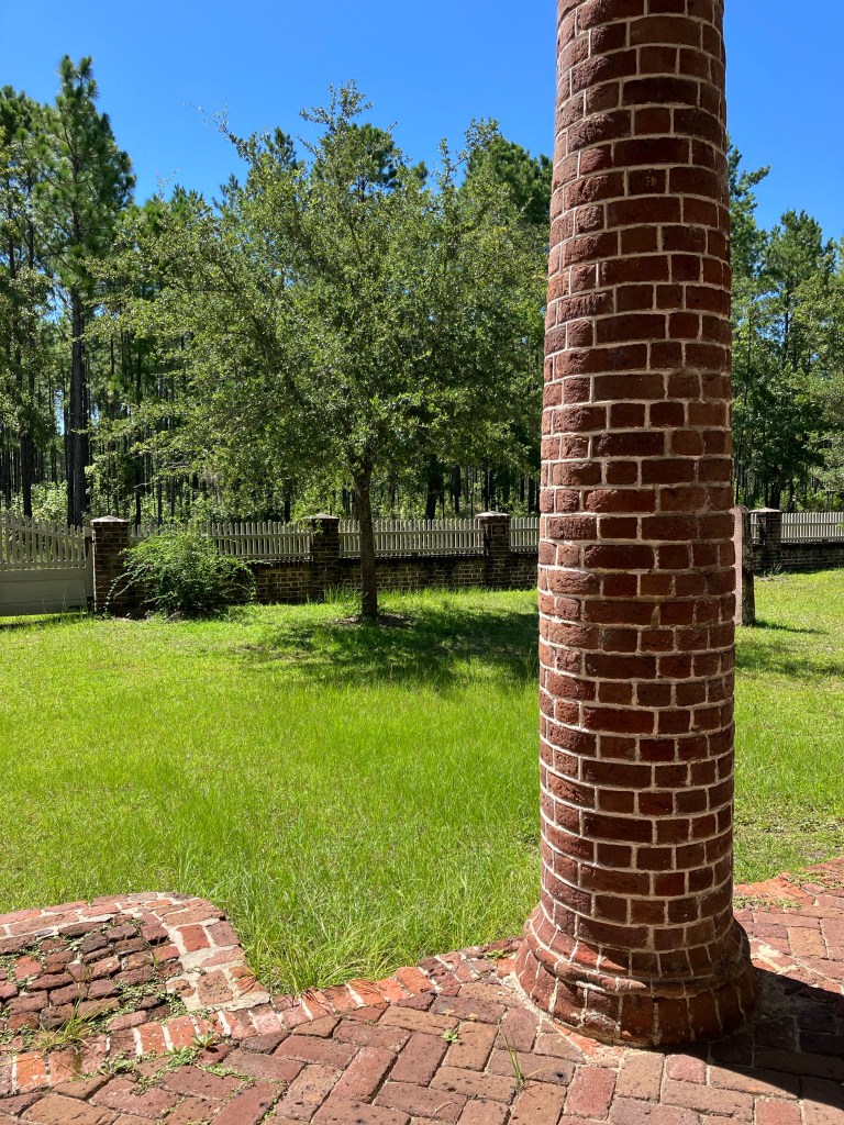 Brick column of the St. James Santee Church portico with the churchyard beyond