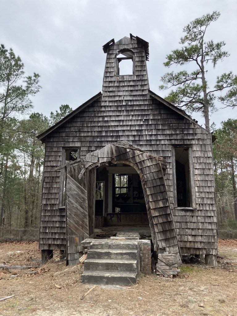 Shingled Halfway Creek Church with its bell tower and front steps