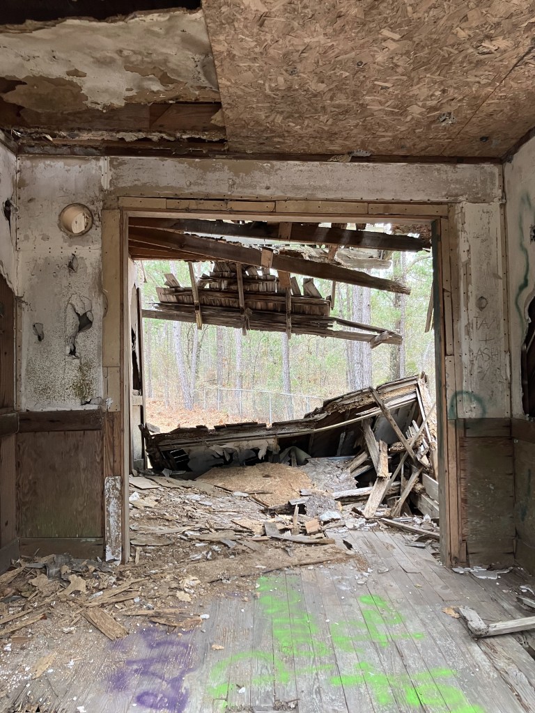 Doorway looking into a ruined room with fallen ceiling boards
