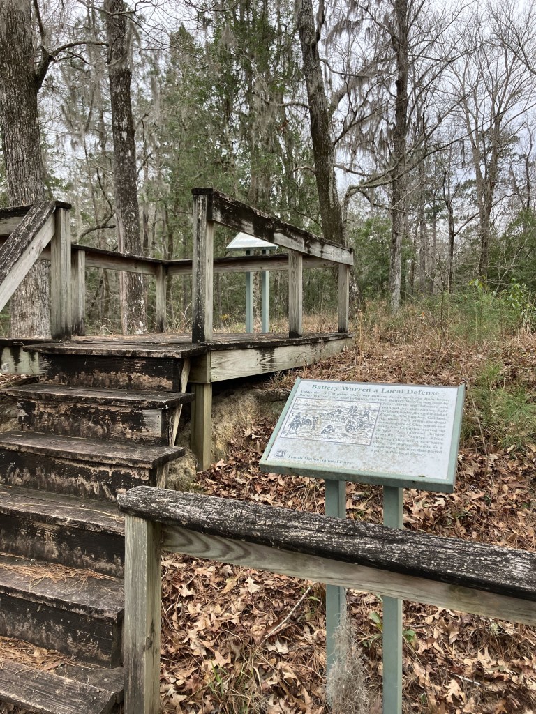 Wooden overlook steps and an interpretive sign at Battery Warren