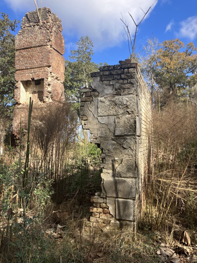 Brick chimney and a stuccoed wall section of the ruins