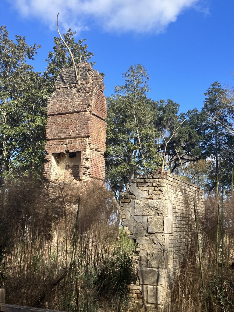 Brick chimney and wall ruins under a blue sky