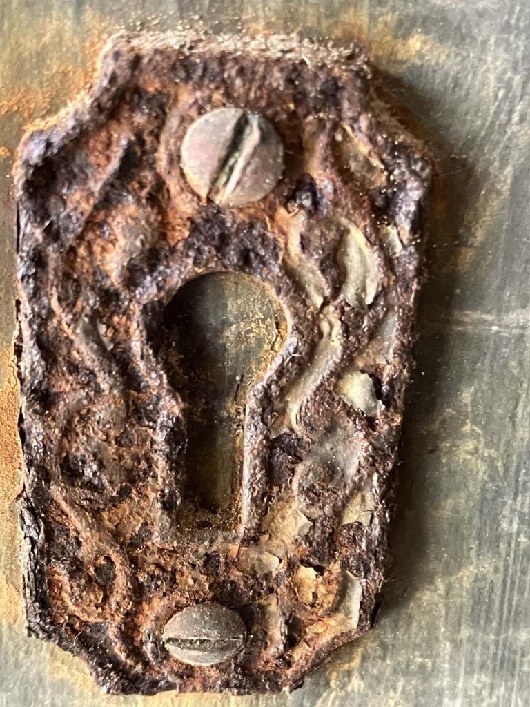 Close view of a rusted iron keyhole escutcheon