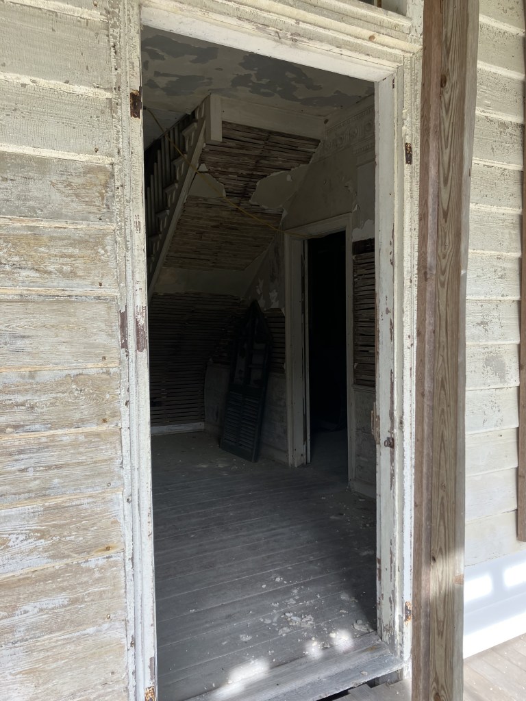 Doorway looking toward the stairs and exposed lath