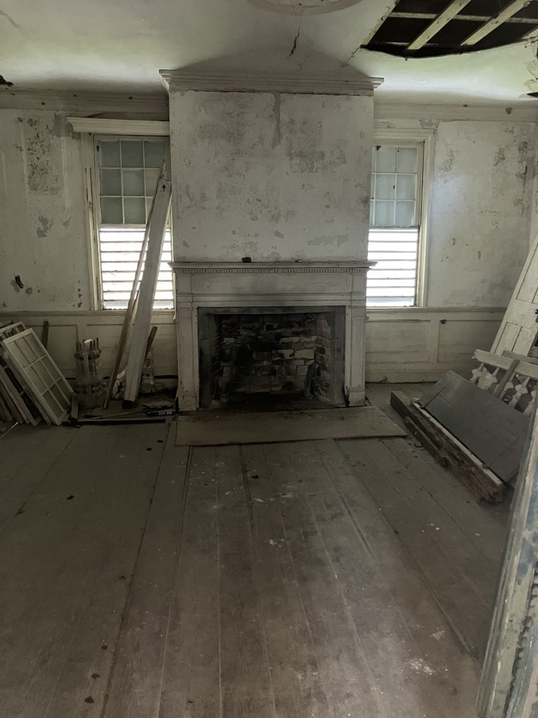 Empty room with a fireplace inside the Tibwin Plantation house