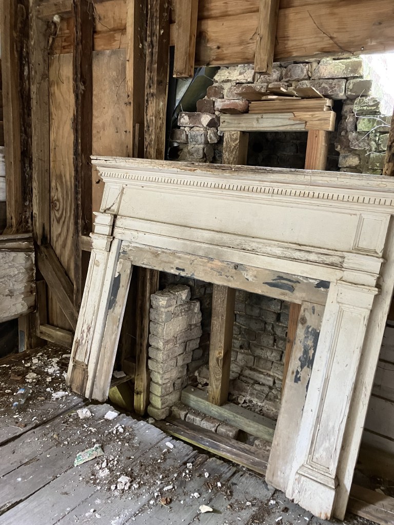 Mantelpiece pulled away from the wall amid fallen plaster and lath