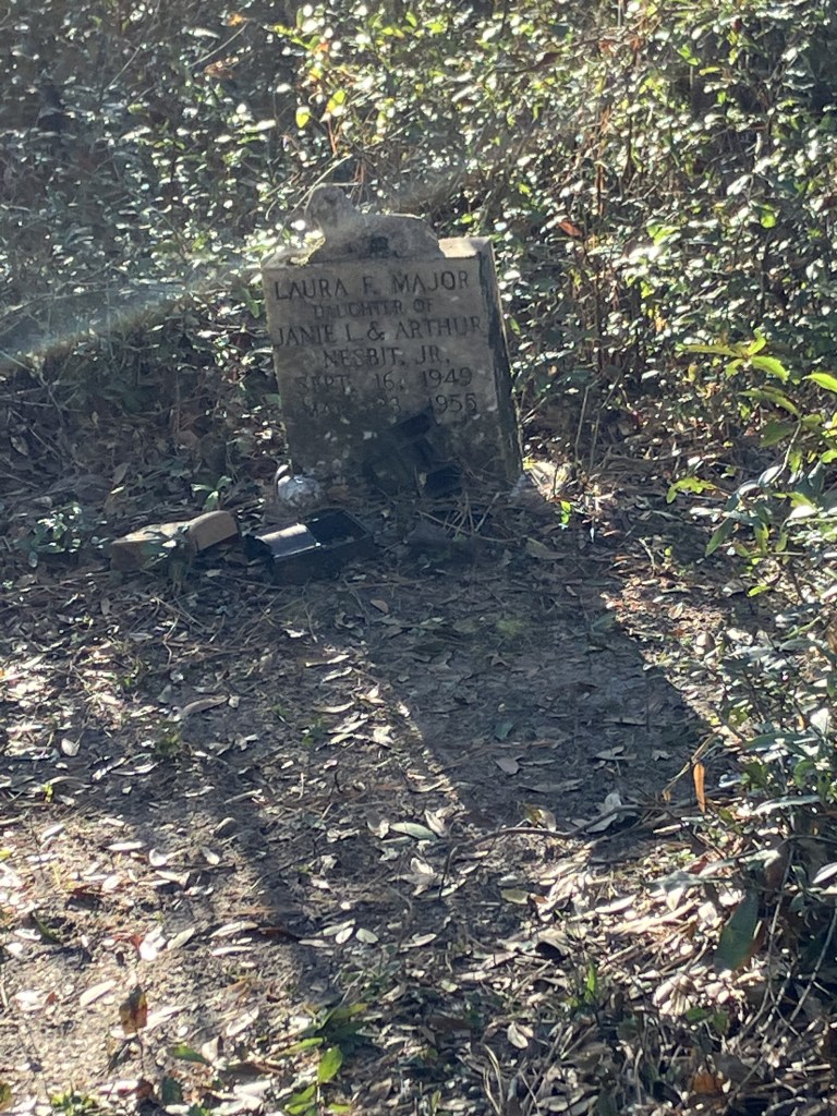 Weathered headstone in dappled light