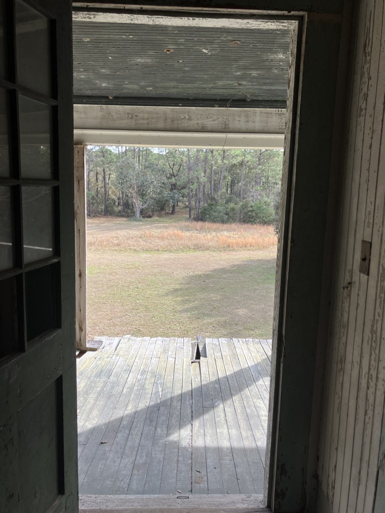 View from the hall doorway across the porch to the field