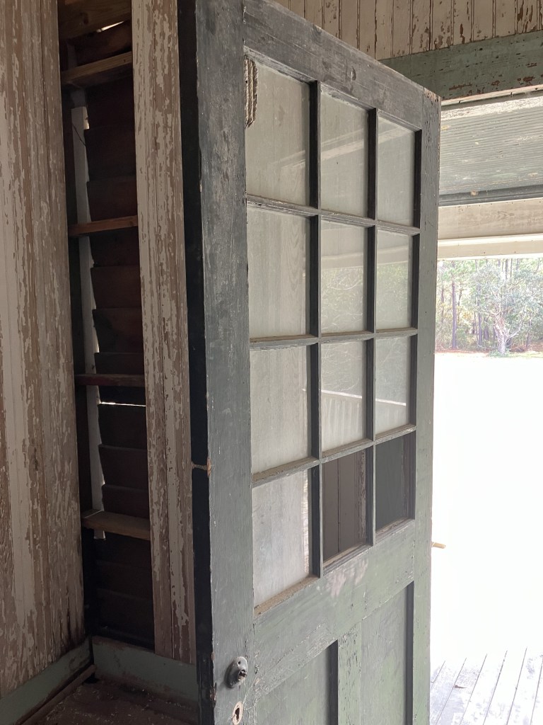 Old door with glass panes opening onto the porch