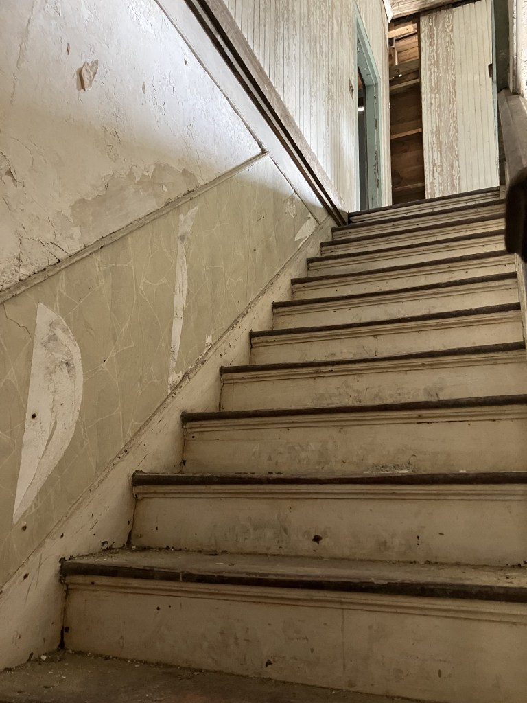 Worn wooden stairs rising to the upper floor