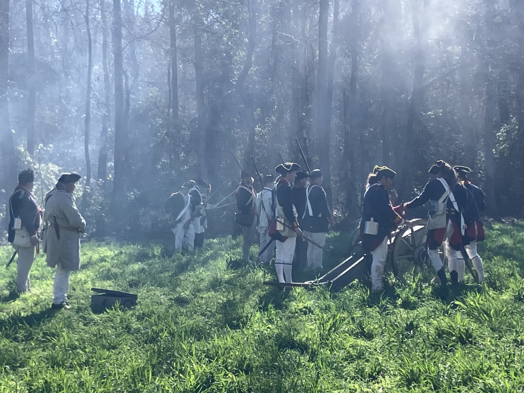 Reenactors loading the field gun in the hazy morning light
