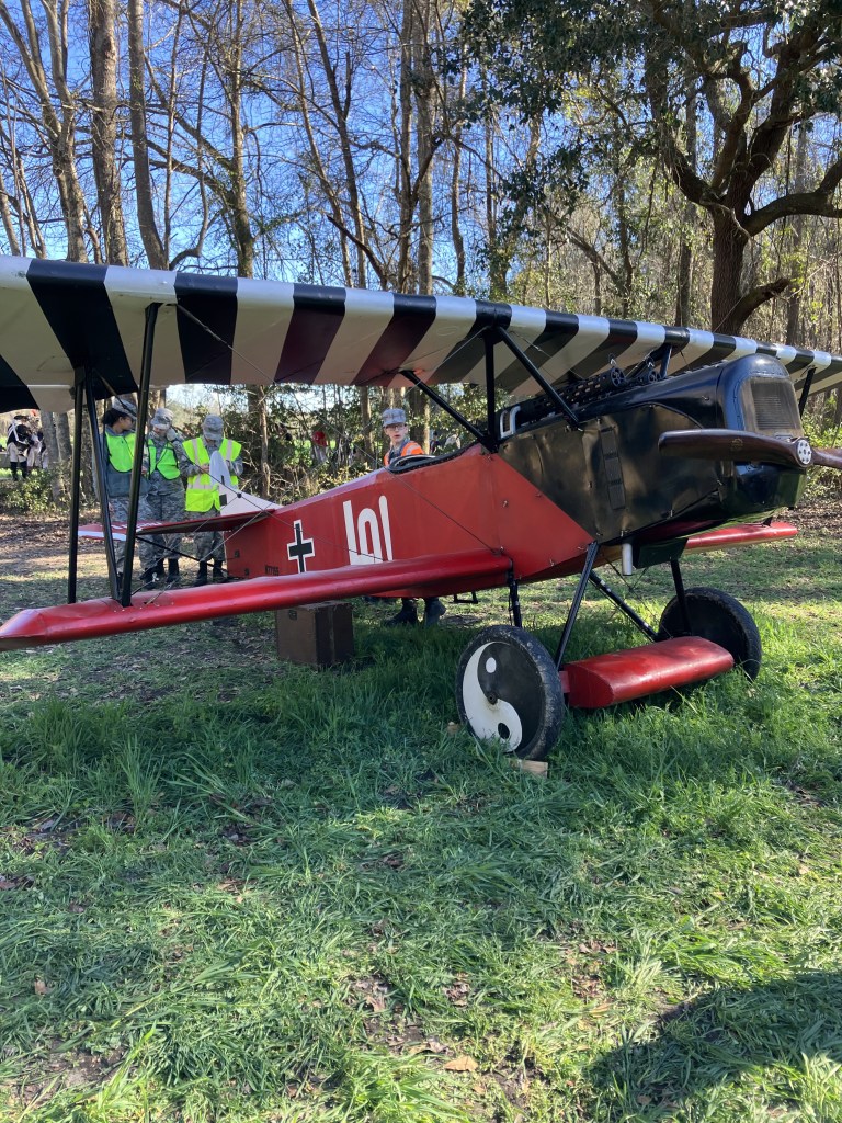 Replica World War I biplane with black-and-white striped wings on display