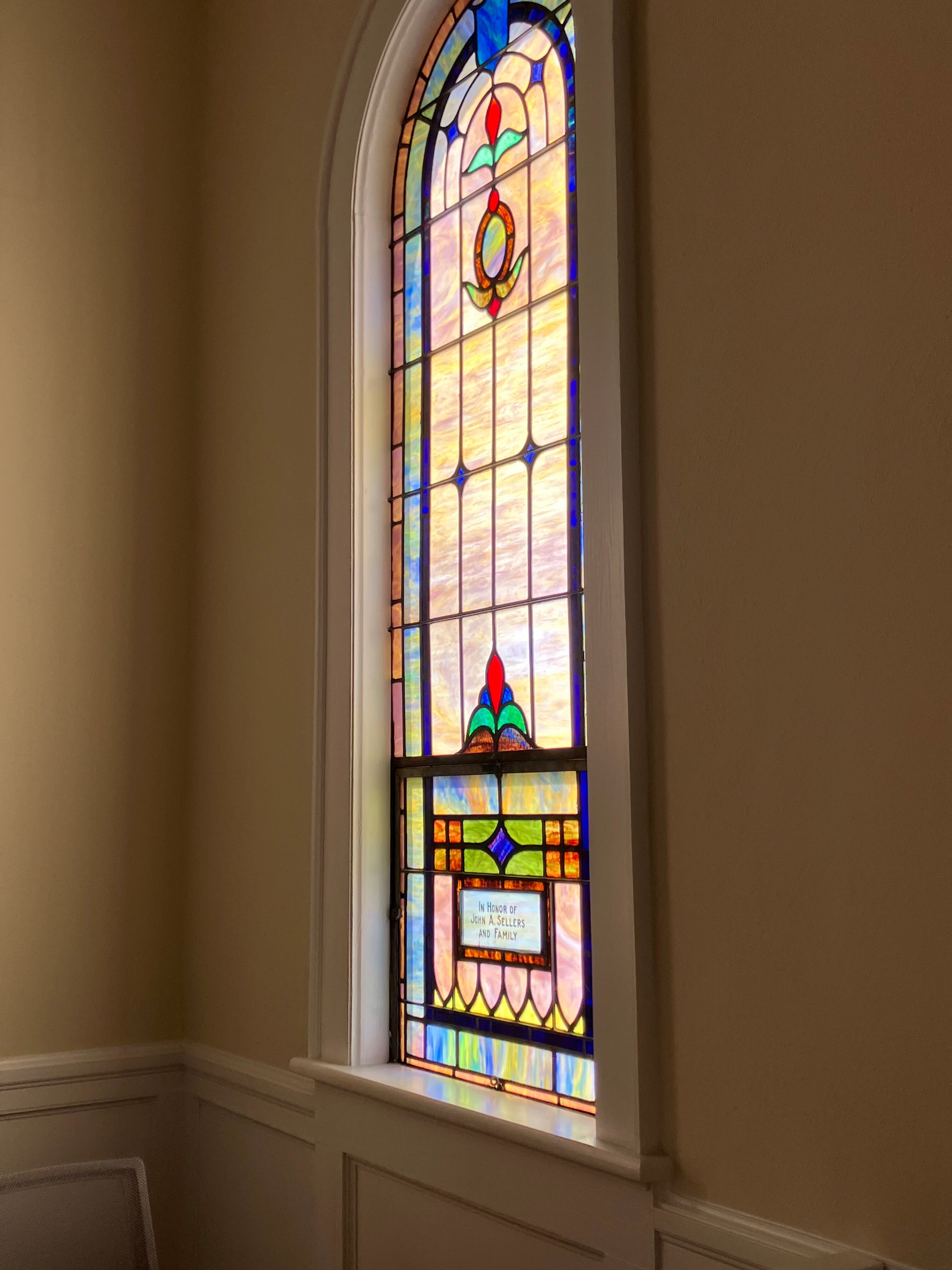 Arched stained glass window in the church sanctuary