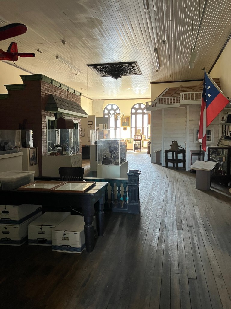 Inside the Cherryville Historical Museum, with exhibit cases and a long wooden floor