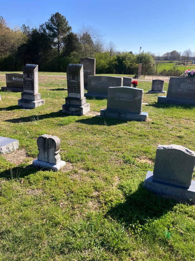 Gravestones across the Mary's Grove Church cemetery under a blue sky