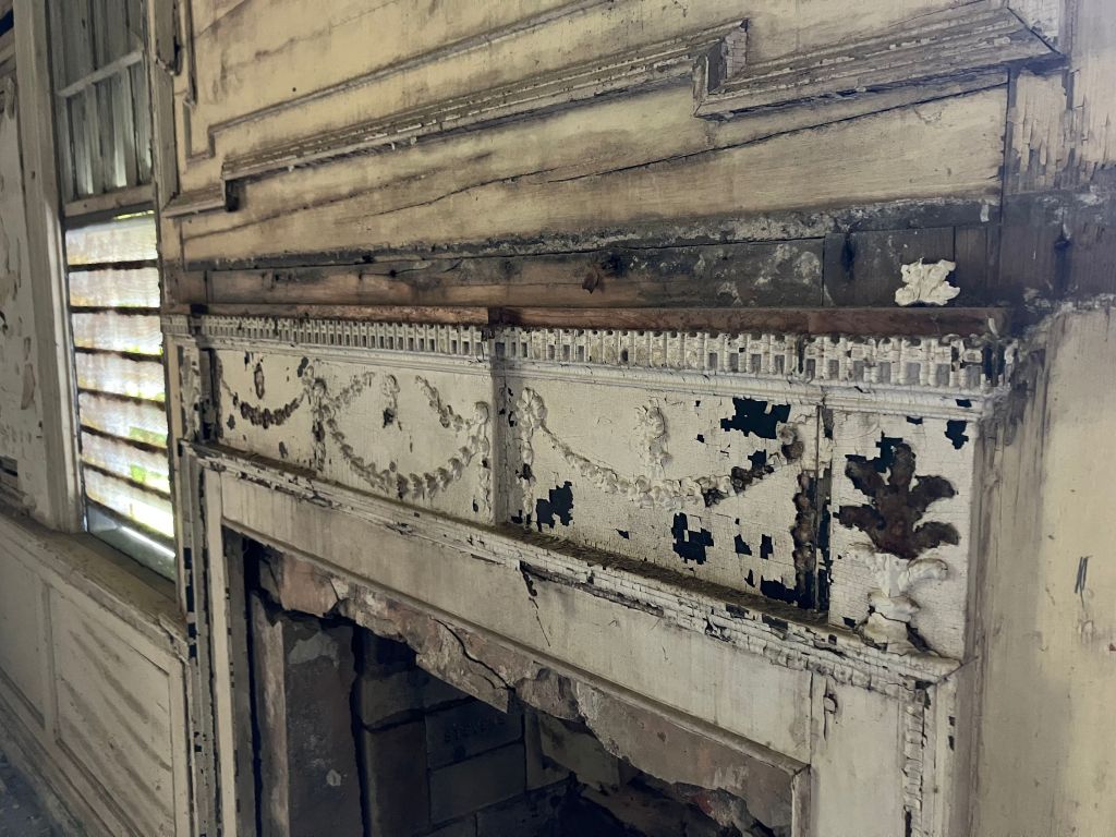 Carved frieze on a mantel with peeling paint