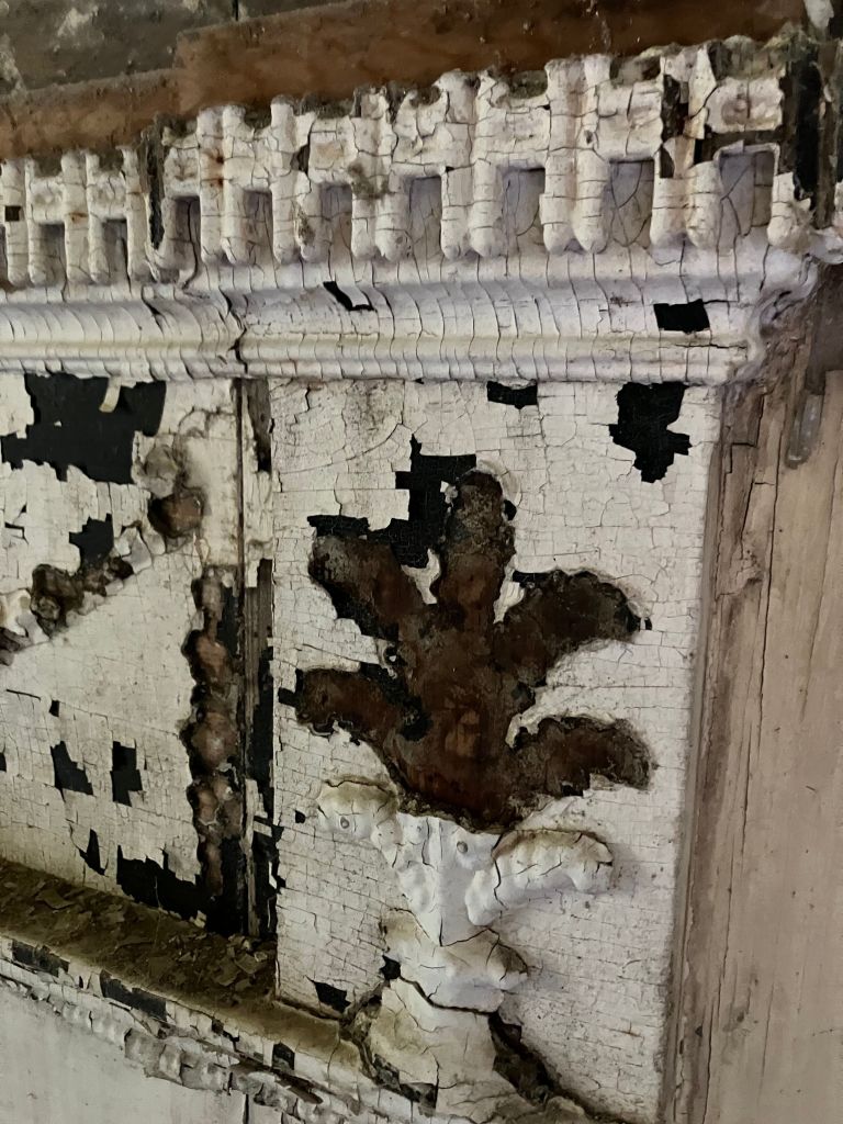 Mantel pilaster with peeling paint and carved molding