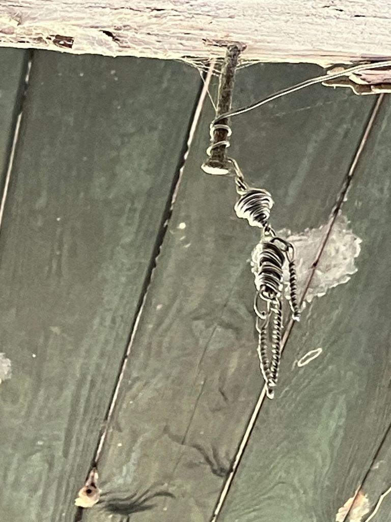The small twisted-wire figure nicknamed Mr. Skelly hanging from the porch beam at Tibwin
