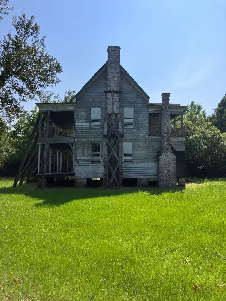 The Tibwin house with its braced porches across the green lawn