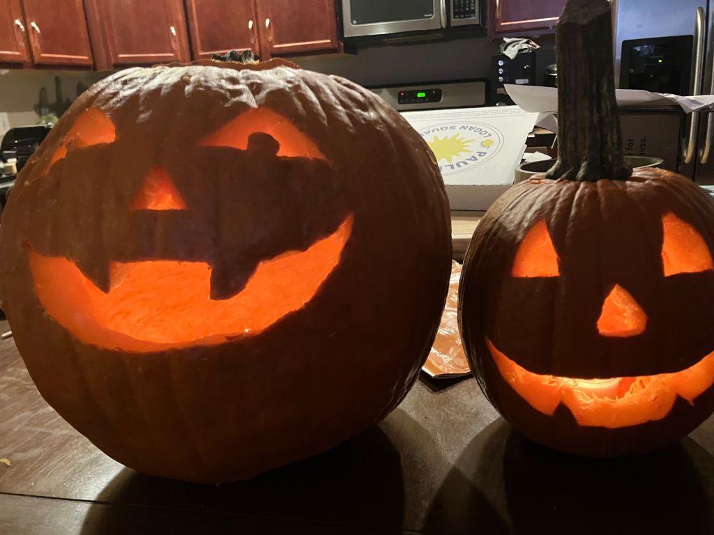Two glowing carved jack-o'-lanterns