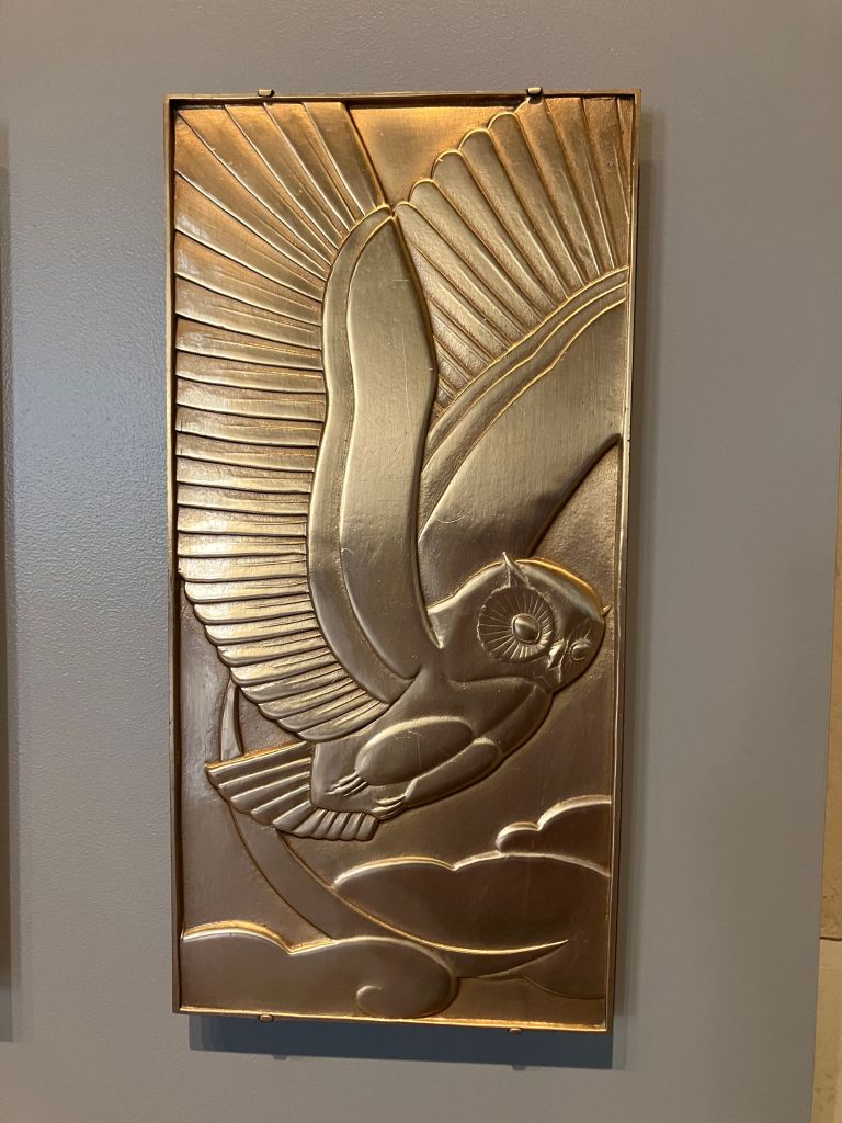 Art deco metal relief of a bird in flight on a wall