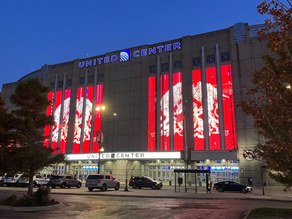 The United Center arena in Chicago lit with red Queen banners at dusk